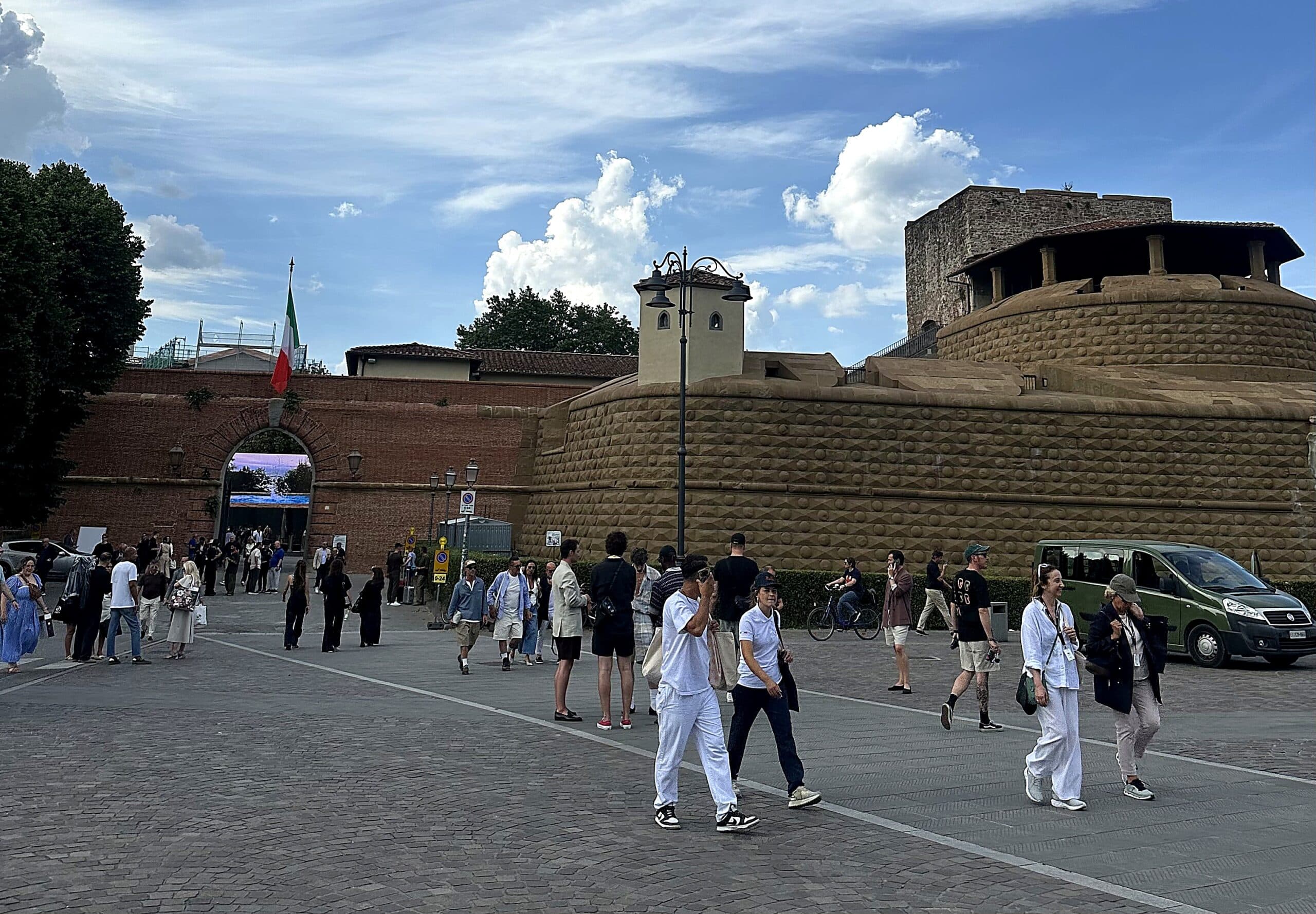 Besökare i stilfulla outfits samlas utanför entrén till Fortezza da Basso under Pitti Uomo 2026 i Florens.