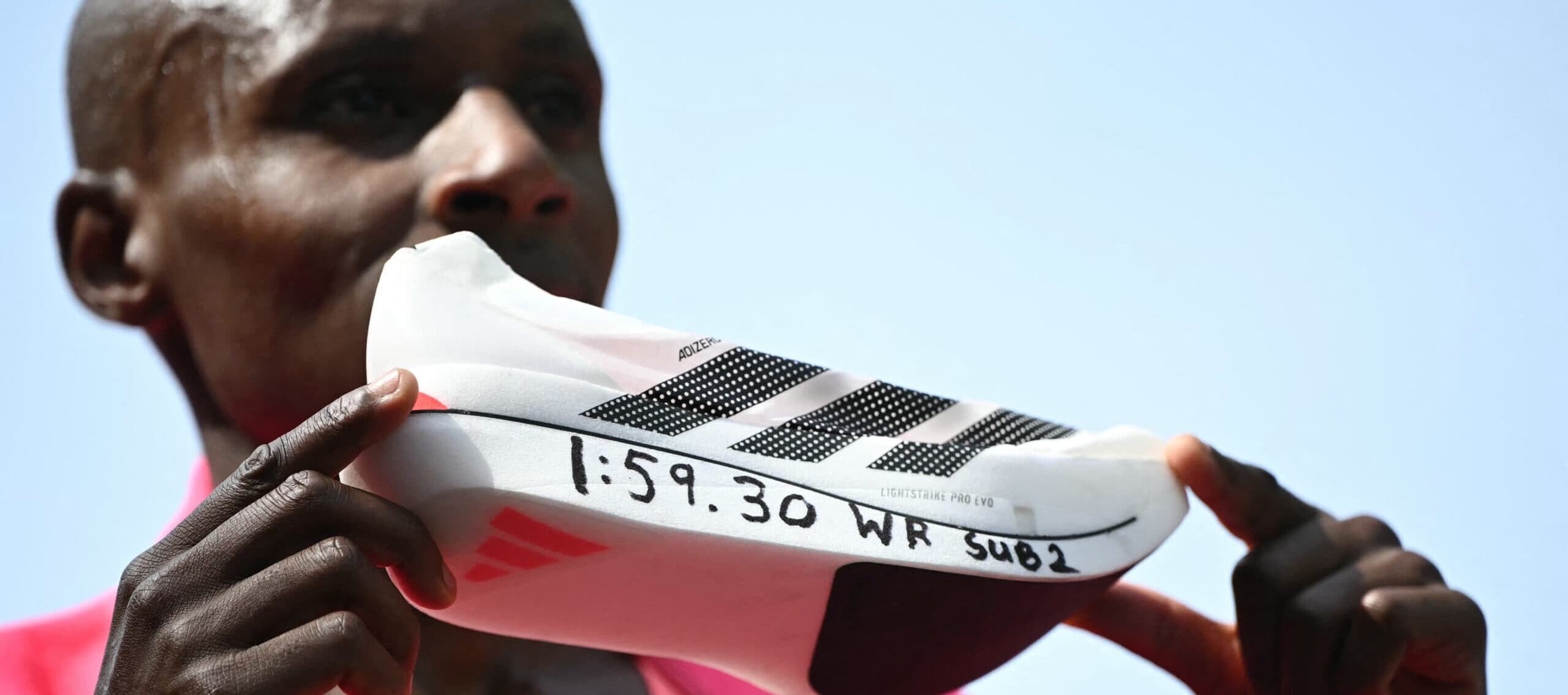 Kenyanen Sabastian Sawe poserar med sin nya världsrekordtid nedskriven på sin löparsko vid målgången av London Marathon 2026 i centrala London den 26 april 2026.