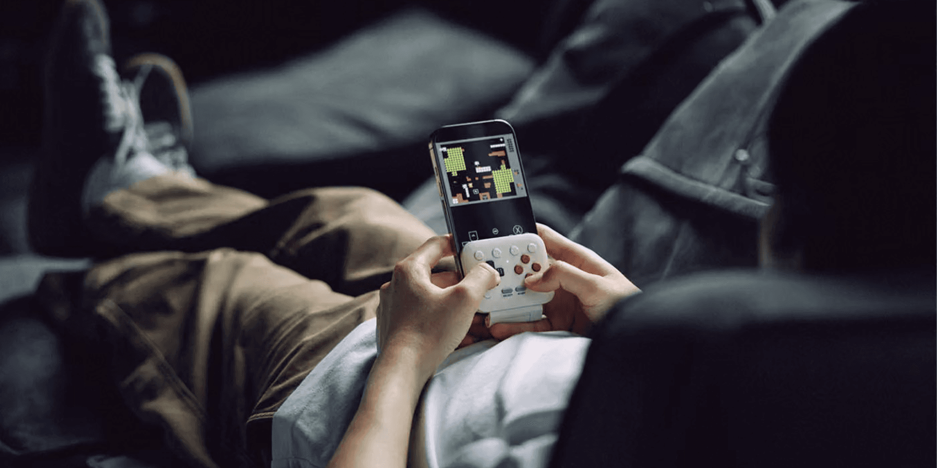 Retrokontrollen 8BitDo FlipPad G Classic Edition fäst på en smartphone.
